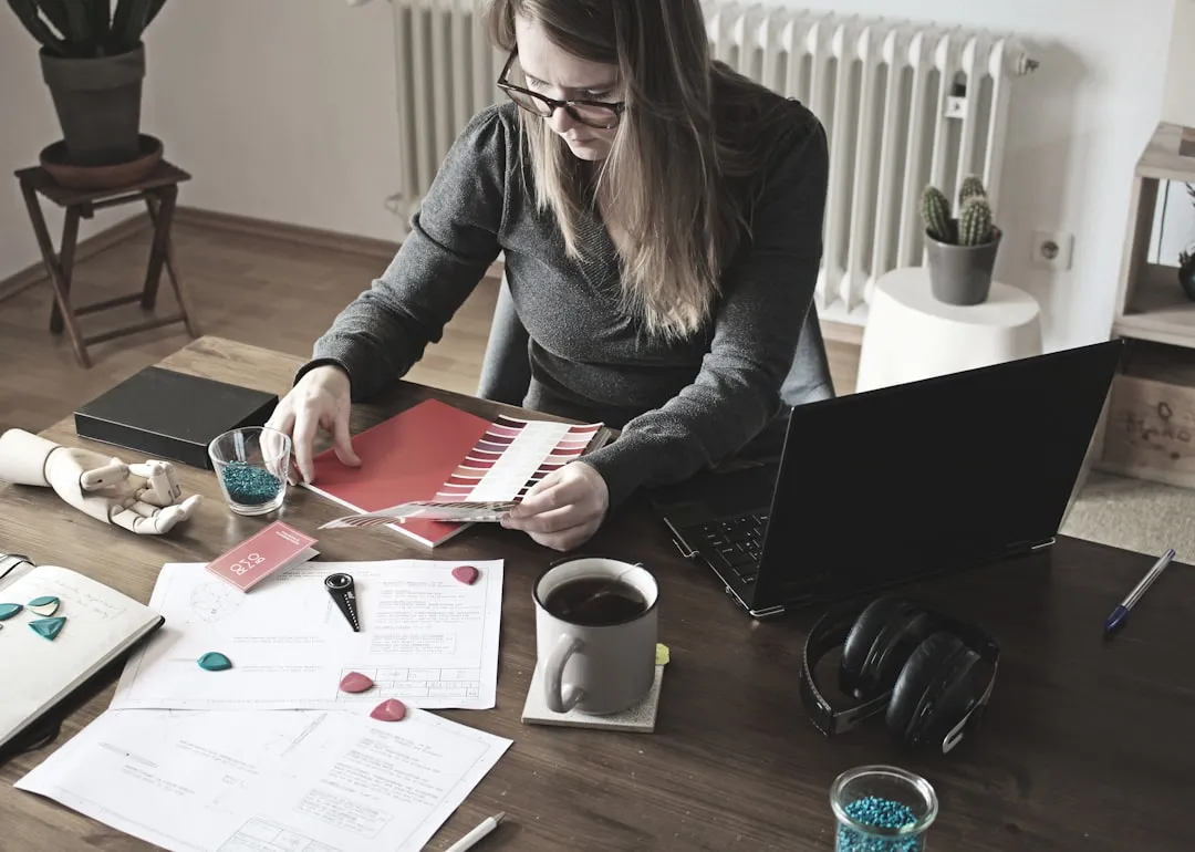 Woman entrepreneur organizing business paperwork at her desk