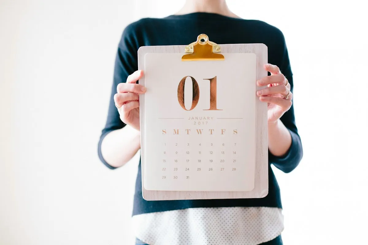 Woman business owner at desk with calendar and laptop showing deadline planning