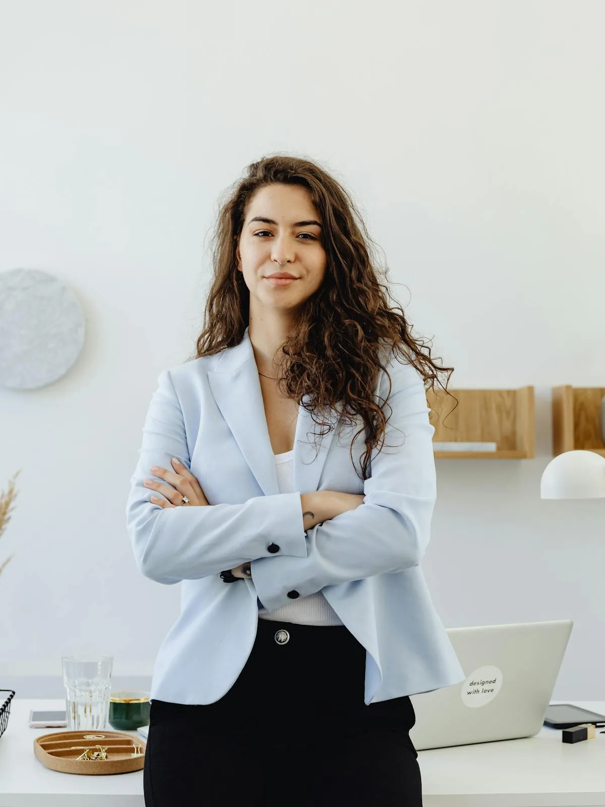 Confident businesswoman standing with arms crossed in a modern office