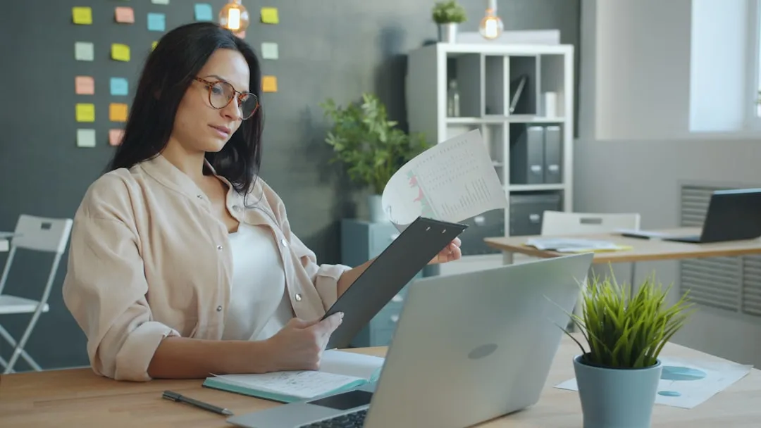 Woman business owner reading financial policy document in office
