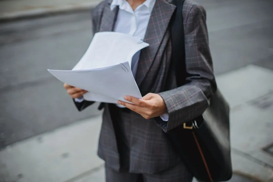 Woman business owner reviewing acquisition financing documents at her desk