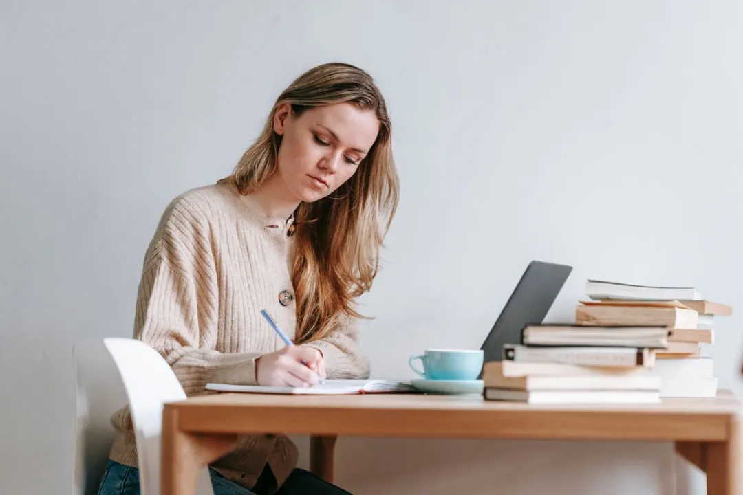 Woman focused at laptop writing a comment in home office
