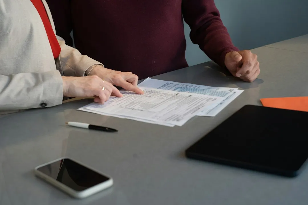 Two people reviewing financial documents at a table